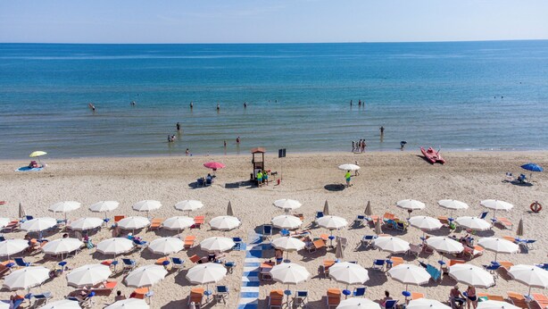 A beach with numerous umbrellas and chairs, a lifeguard tower, and the sea in the background. - HOTEL ACQUARIO (Marina di Vasto)