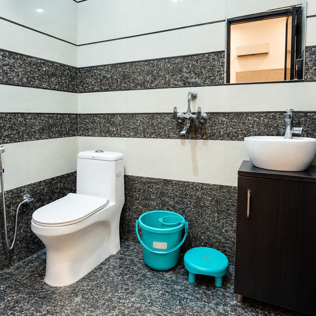 A bathroom with a toilet, sink, and a small stool.
