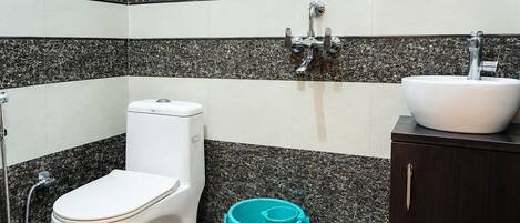 A bathroom with a toilet, sink, and a small stool.