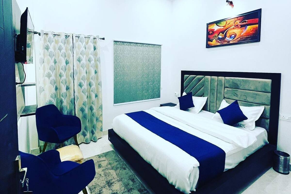 Un dormitorio moderno con una cama grande, un escritorio y una silla.