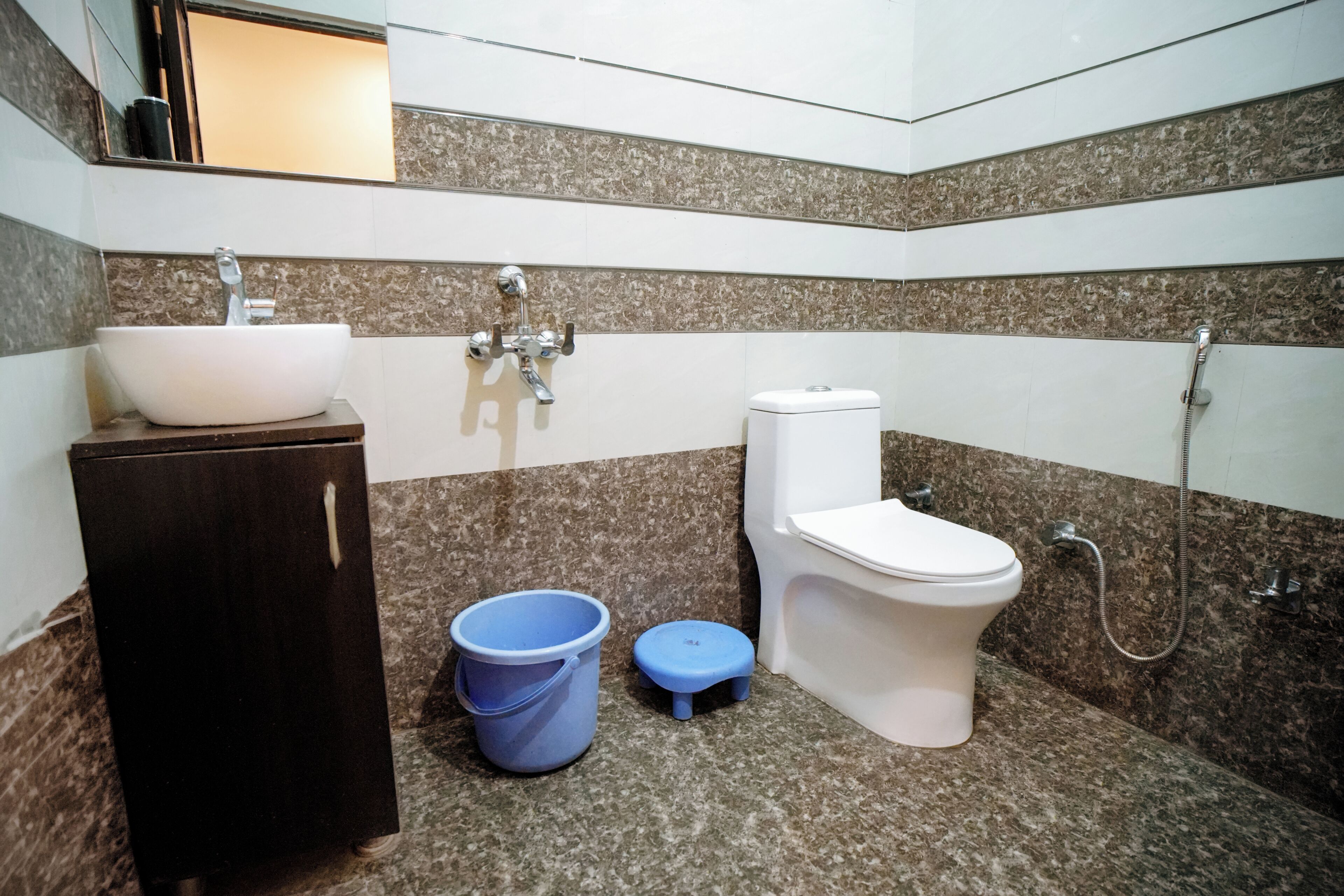 A bathroom with a white sink, a toilet, a bidet, and a shower.