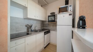 A compact kitchen with white cabinets, a microwave, a coffee maker, and a dishwasher. - Charming apartment for 6 people, mountain view, ski slope (Allos)