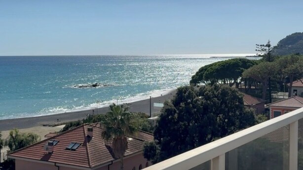 A coastal view with a beach, ocean, and residential buildings. - International Holiday House, cozy apartments by the sea (Diano Marina)
