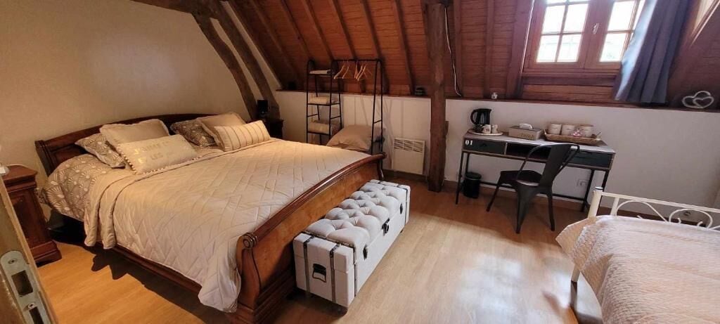 Une chambre mansardée chaleureuse avec un lit en bois, un bureau et un lit superposé.