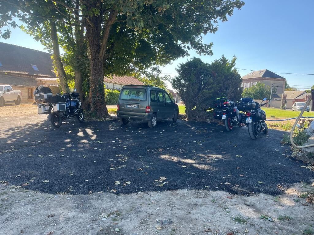 A parking area with two motorcycles and a van.