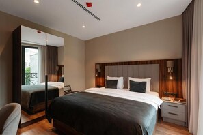 A modern hotel room with a large bed, a bedside table, a mirror, and a view of the outdoors. - White Hill Hotel Tbilisi (Tbilisi)