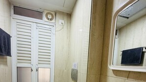 A bathroom with a toilet, sink, and mirror. - 1BR Service Apart Parel 3701 Near TMH By Florastays (Mumbai)