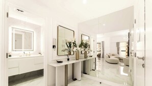 Une salle de bain moderne avec un sol en marbre, un meuble-lavabo avec un miroir et une console agrémentée de vases.