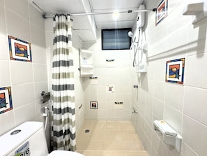 Un baño pequeño con ducha, inodoro y un perchero para toallas.