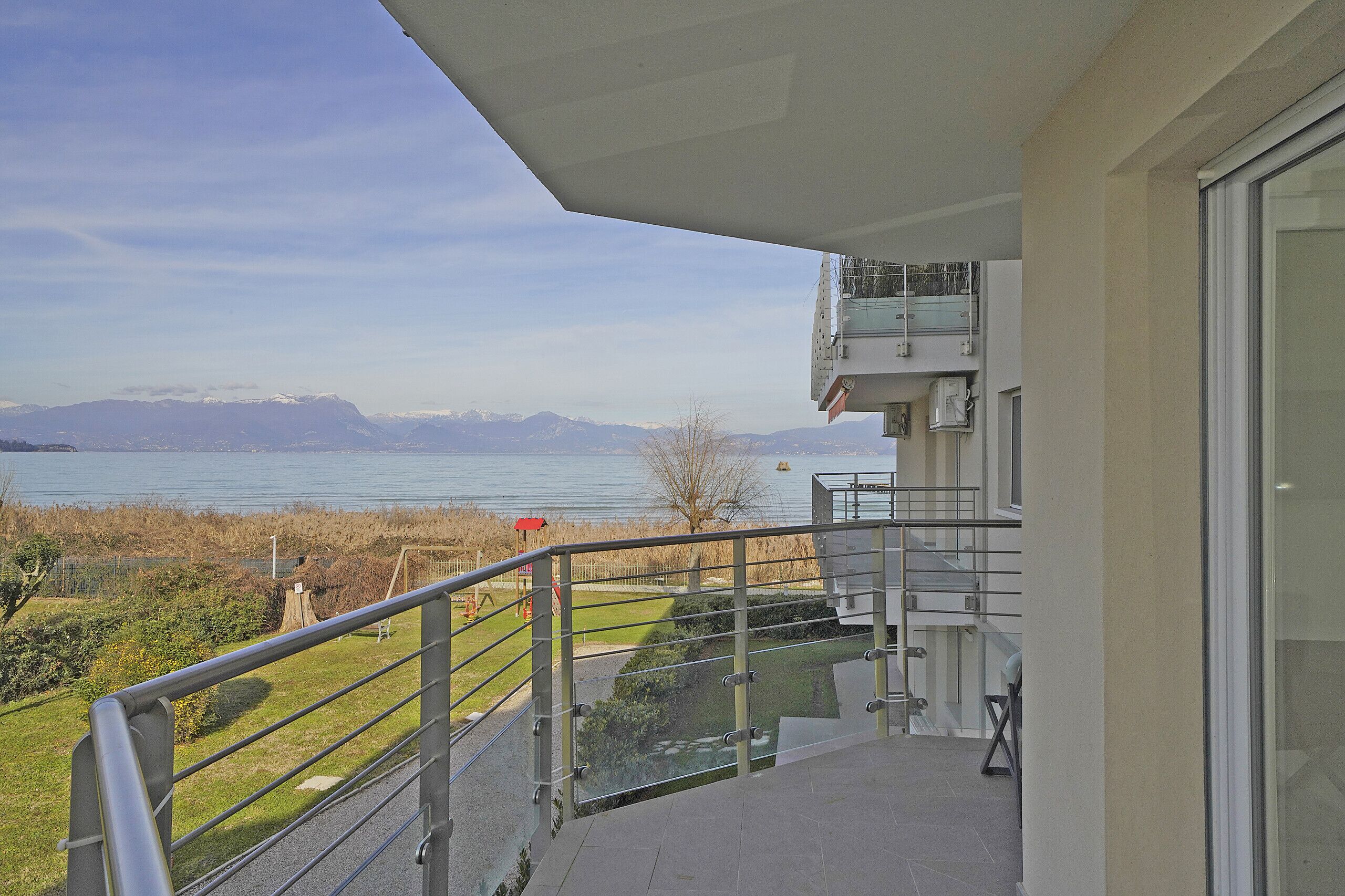 A balcony with a view of a lake and mountains.