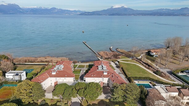 A lakeside property with two buildings, a dock, and a swimming pool. - Sunset on Sirmione in Sirmione (Sirmione)