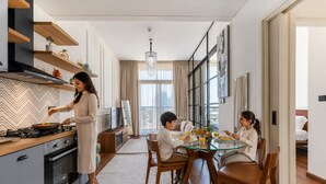 Een moderne keuken met een eethoek, een kroonluchter en een groot raam.