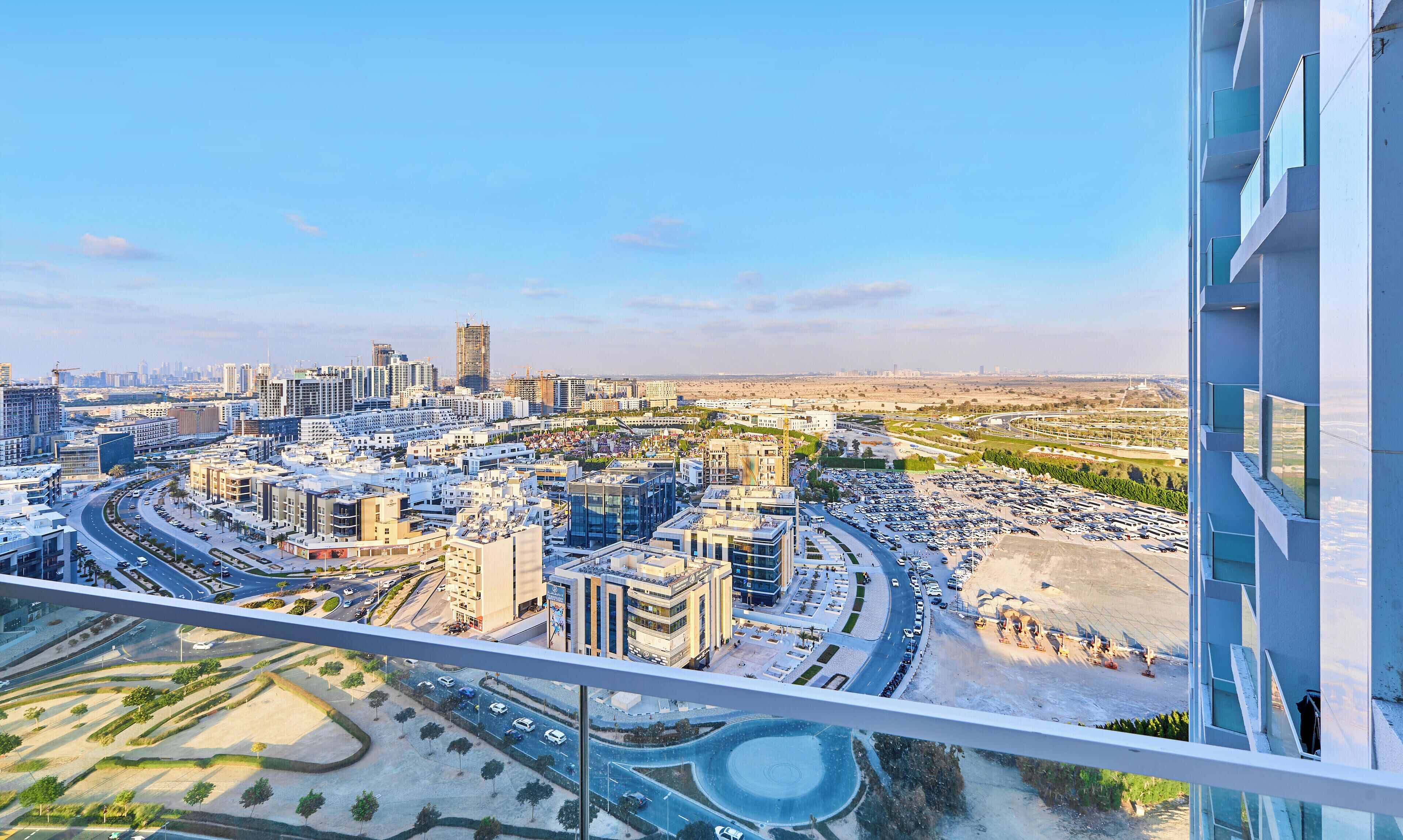 Um edifício alto com vista para uma paisagem urbana, incluindo ruas, edifícios e canteiros de obras.