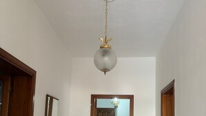 Ein Flur mit Holztürrahmen, Heizkörper und Spiegel an der Wand.