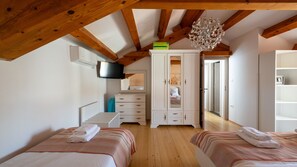 A bedroom with two beds, a TV, a wardrobe, and a chandelier. - Villa Katarina by Villas Guide (Barban)