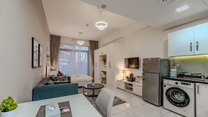 En modern lägenhet med vardagsrum, matplats, kök och tvättstuga.