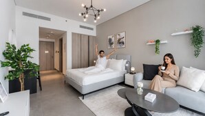 Een moderne hotelkamer met een bed, een bank, een salontafel en een eettafel.