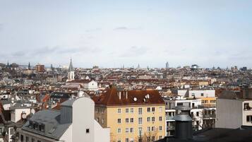Un paysage urbain caractérisé par un clocher d’église imposant, des immeubles denses et un mélange de bâtiments résidentiels et commerciaux.