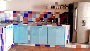 A kitchen with a tiled backsplash, a gas stove, a sink, and a stainless steel refrigerator. - Cozy apartment historic center Cartagena Colombia (Cartagena de Indias)