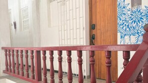 A staircase with a red balustrade leading to a wooden door. - Cozy apartment historic center Cartagena Colombia (Cartagena de Indias)