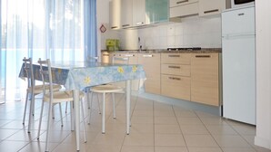 Eine moderne Küche mit Essbereich, inklusive Tisch, Stühlen, Kühlschrank und Schränken.