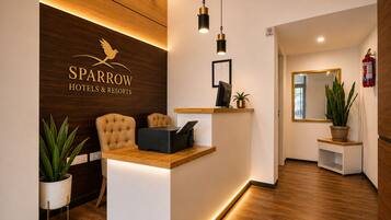 A reception desk with a wooden backdrop, a framed certificate, and a fire extinguisher.
