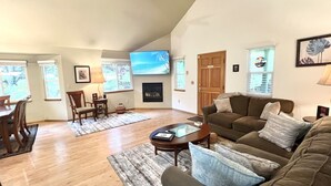 Ein Wohnzimmer mit Kamin, Fernseher und einer Couch.