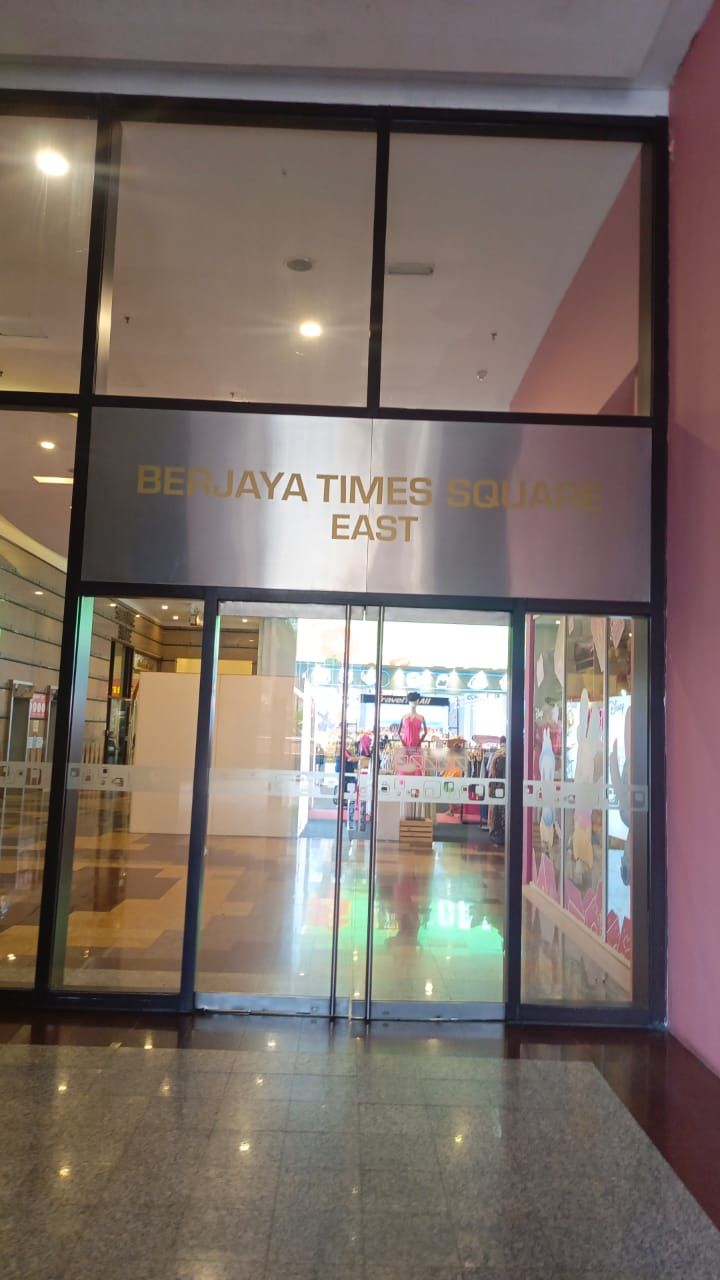 Une entrée d’immeuble avec une enseigne indiquant « BERJAYA TIMES SQUARE EAST ».
