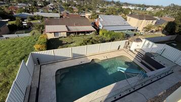 A residential area with a swimming pool, houses, and a view of the ocean.