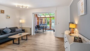 Un salon moderne comprenant un canapé, une table basse et un coin repas avec des chaises et une table.