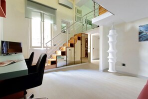 Ein modernes Interieur mit Treppe, Essbereich und einer einzigartigen weißen Skulptur.