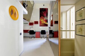 A modern office space with a long corridor, red and black office chairs, and a large painting on the wall. - MARGUTTA LOFT FOR SMART WORKER (Roma)