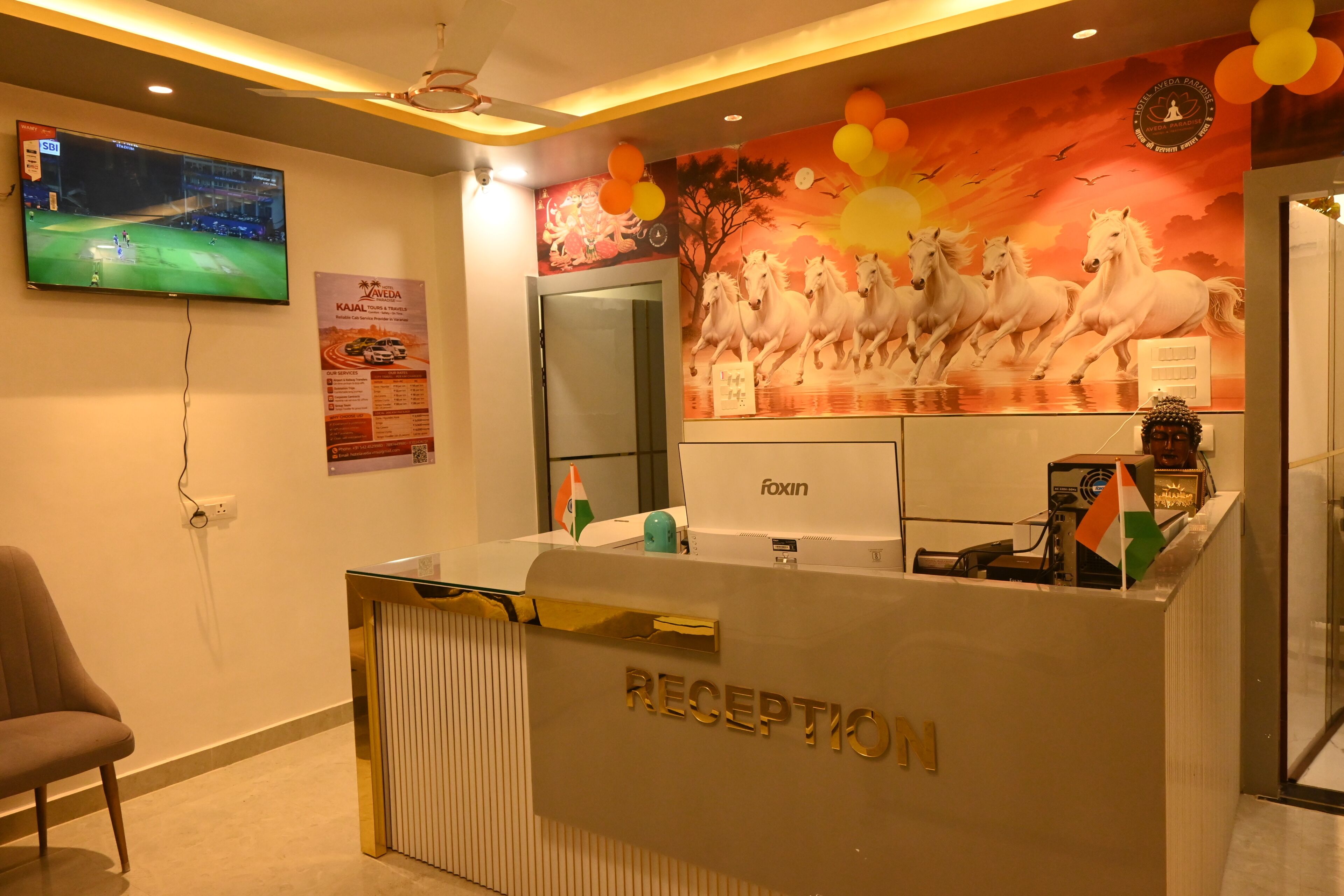 A reception area with a TV, a wall mural, and a reception desk.