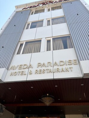 Ein Hotel-Schild mit der Aufschrift 'Aveda Paradise Hotel & Restaurant'.