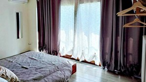 A bedroom with a bed, a window with curtains, a wooden ceiling, and a wall-mounted air conditioner. - Sunflowers abode Your rustic home in the center of all Tuscan destinations! (Toscana)