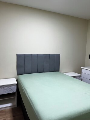 A bedroom with a bed, a nightstand, a dresser, and a wall-mounted clock. - Apartment on Dunas Beach, 6 minutes from Forte Beach in Cabo Frio. (Cabo Frio)