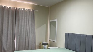 A hotel room with a bed, a nightstand, a mirror, and a ceiling light. - Apartment on Dunas beach, 6 minutes from Forte beach in Cabo Frio. (Cabo Frio)