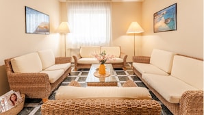 A cozy living room with wicker furniture, a central coffee table, and two lamps. - Stylish Residence House in Alghero (Alghero)
