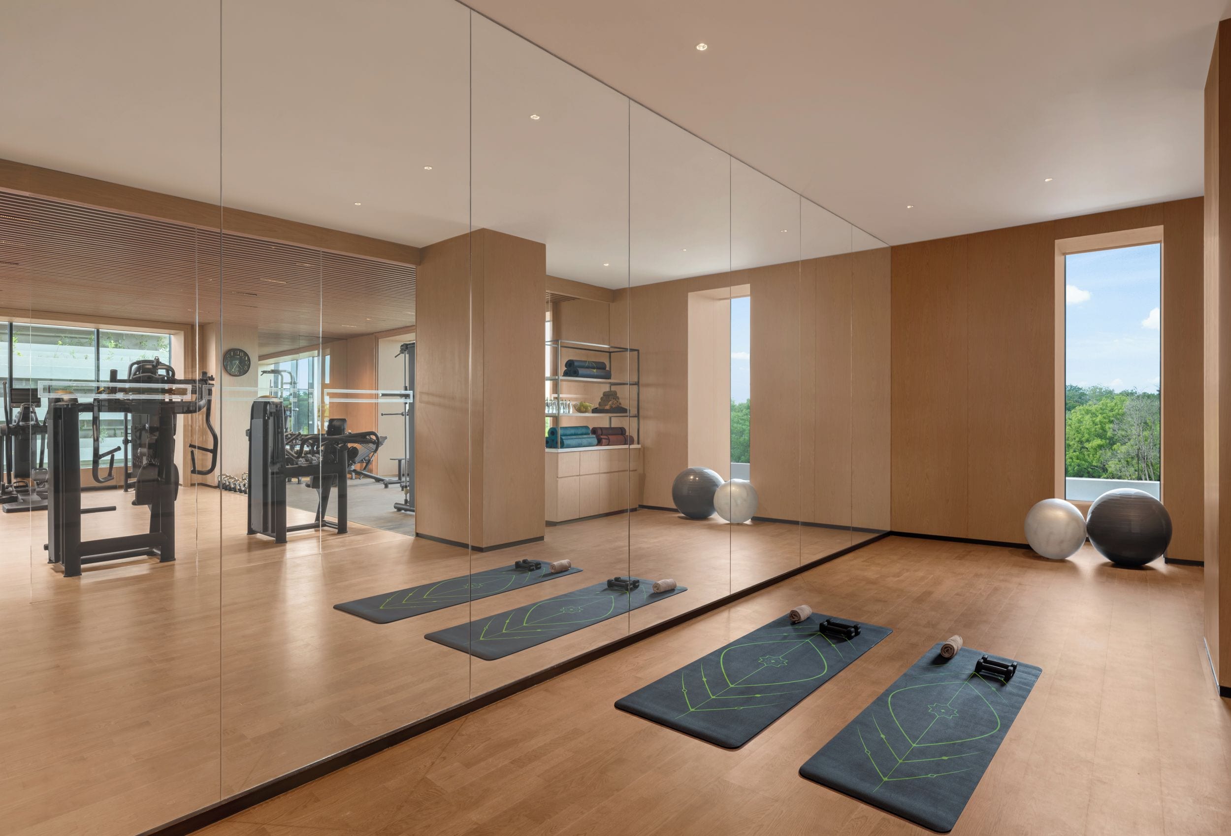 A gym with exercise equipment, yoga mats, and large exercise balls.