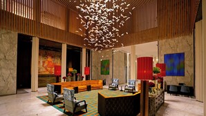 A lobby with a reception desk, seating area, and artwork on the walls.