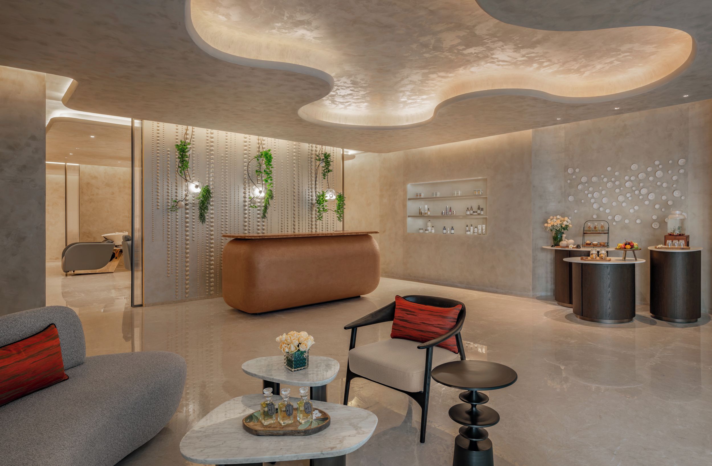 Un hall d’entrée moderne avec un comptoir d’accueil incurvé, un espace salon et des panneaux muraux décoratifs.
