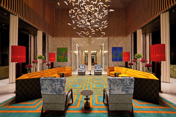 A lobby with a central seating area, a patterned carpet, and a modern ceiling design. - The Residency Signature Madurai (Madurai)