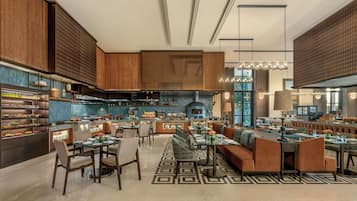 Un restaurante moderno con zona de comedor central, cocina y espacio de bar-lounge.