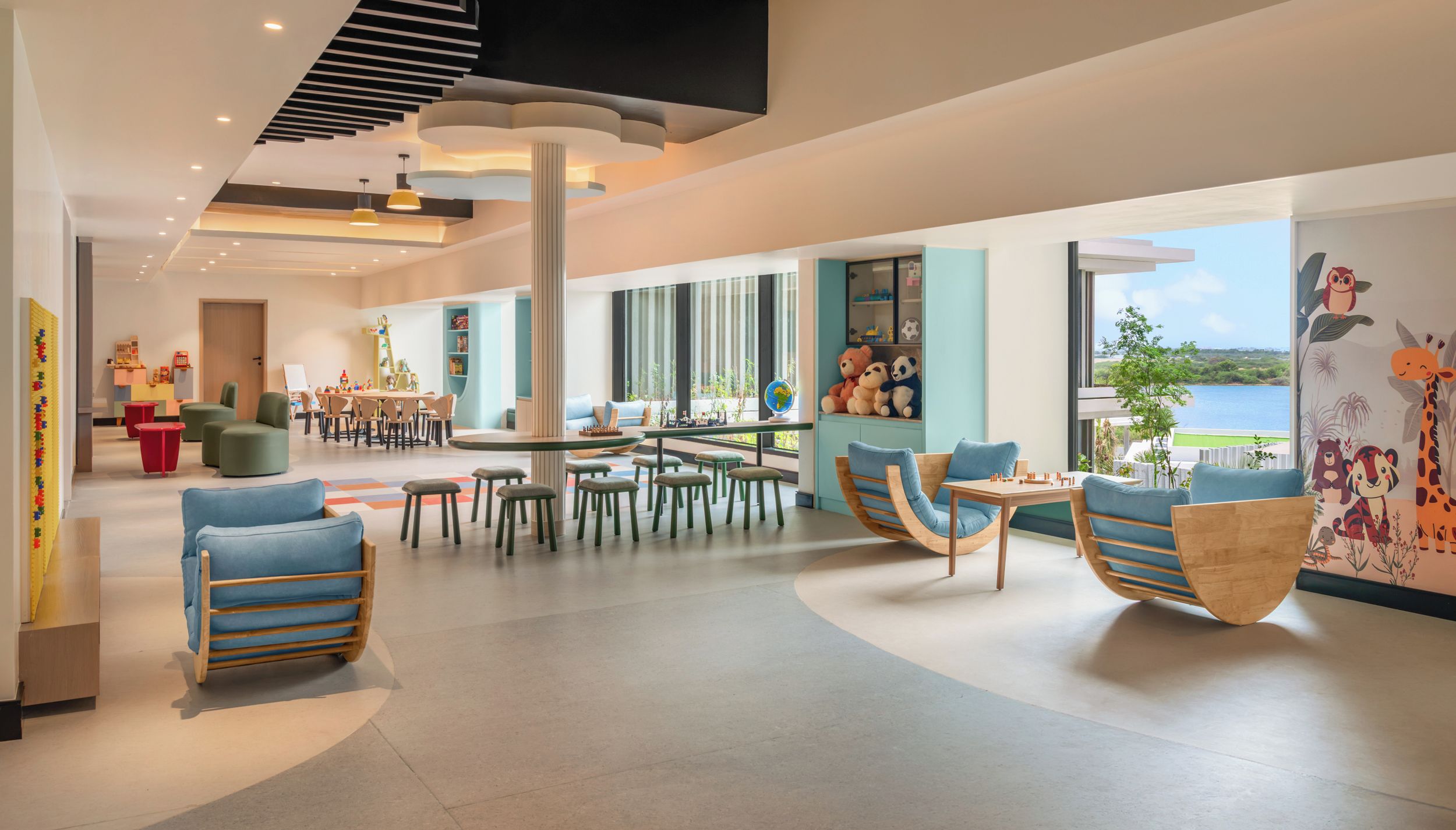 A spacious indoor area with multiple seating arrangements, including chairs and tables, and a large window providing a view of the outdoors.