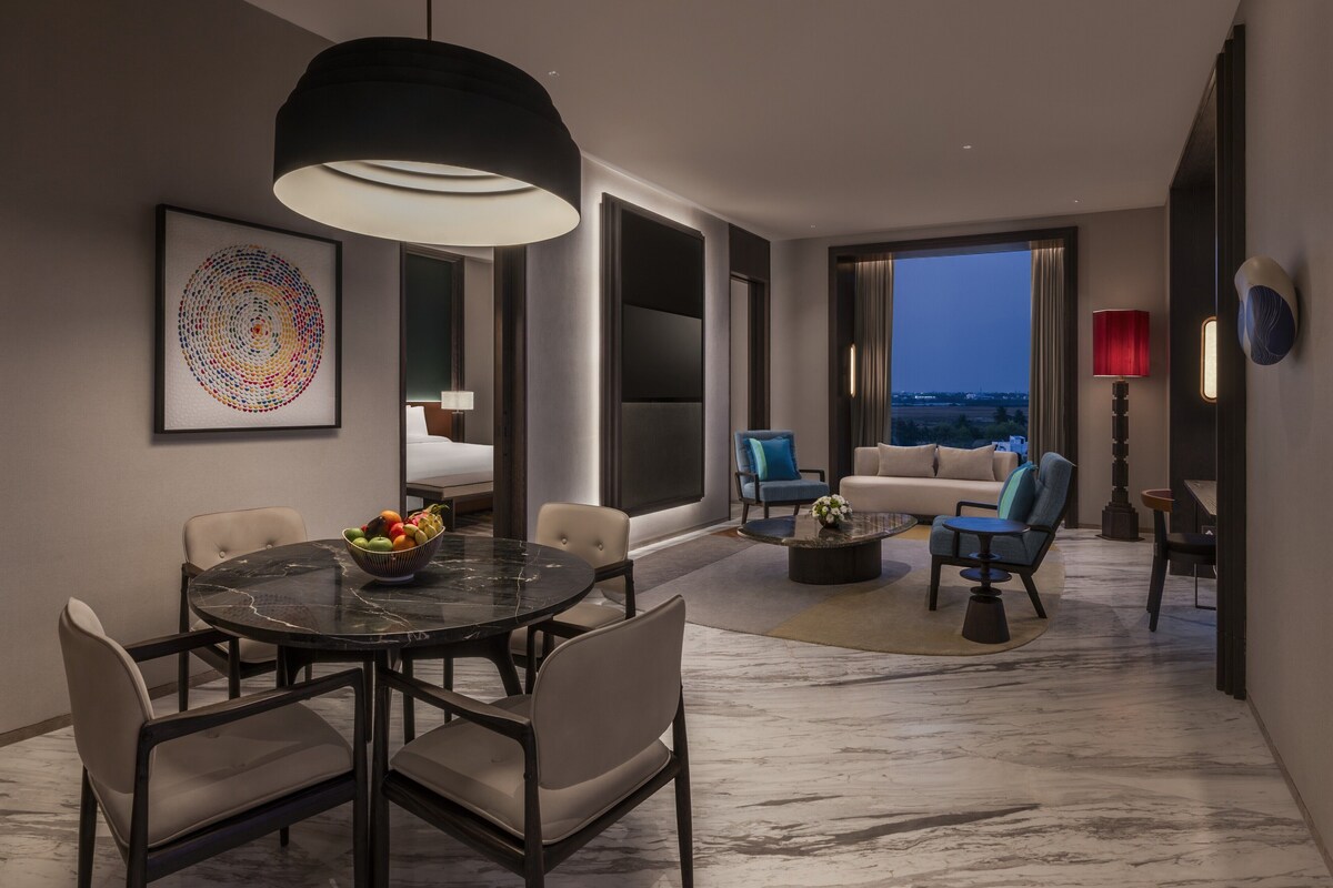 A modern interior with a dining area, seating, and a large window.