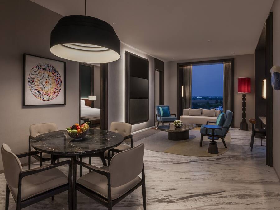 A modern interior with a dining area, seating, and a large window.