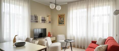 A modern living room with a dining table, sofa, and TV.