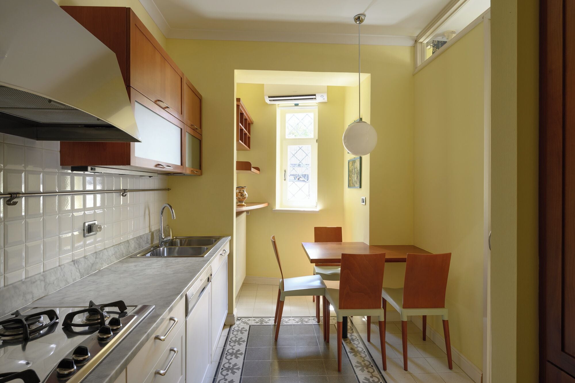 A compact kitchen with a gas stove, a sink, and wooden cabinets.