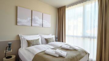 Une chambre d’hôtel avec un grand lit, des murs de couleur beige et une fenêtre avec des rideaux.