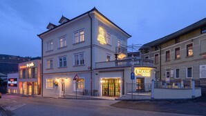 A multi-story building with a prominent 'FRANZ BISTRO' sign, a 'FRANZ APARTMENTS' sign, and a 'BALADUR' sign. - Franz Apartments  (Ilirska Bistrica)